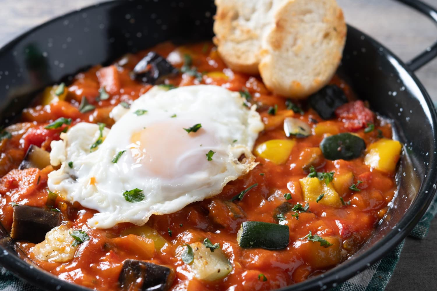 Palomitas y cebollas de huevo pimientos servidos en sartén en mesa de madera pisto manchego de verduras con tomates calabacín